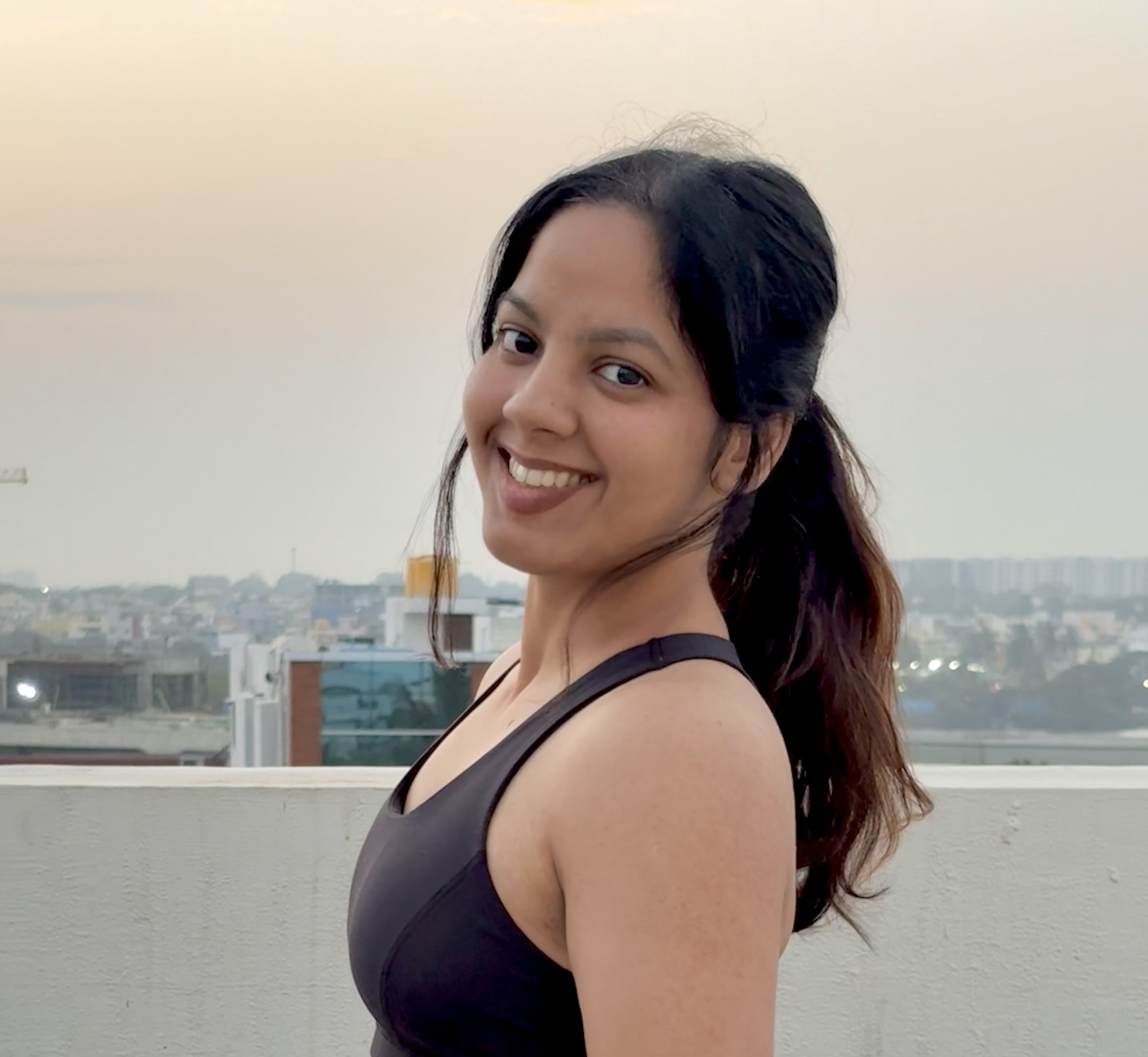 Kangna Saini, certified fat loss coach, smiling on a rooftop
